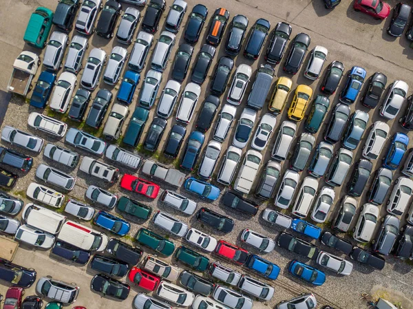 Aerial view of car park with many car standing in chaotic order 