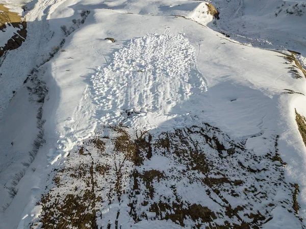 Aerial view of snow avalanche on mountain slope.