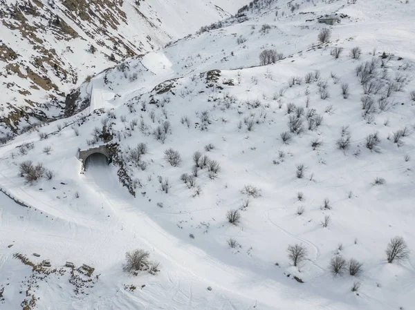 冬の風景の中に雪に覆われた道路とトンネルの空中ビュー — ストック写真