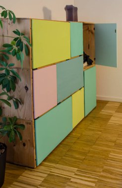 Giysiler için renkli kapıları olan şarap kutularından yapılmış ev yapımı dolap.