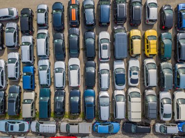 Aerial view of car park with many car standing in chaotic order 
