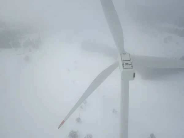 Aerial view of wind turbine in snow covered landscape