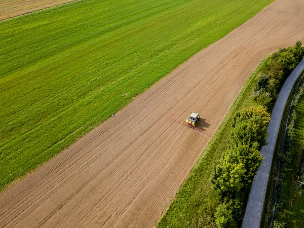 農地に農薬を散布するトラクターの空中ビュー — ストック写真