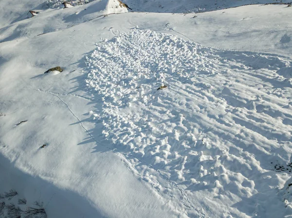 Aerial view of snow avalanche on mountain slope.