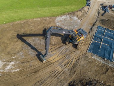 İnşaat alanındaki büyük kazıcının hava görüntüsü.