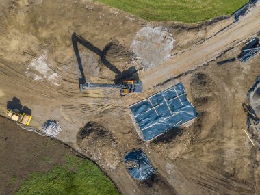 İnşaat alanındaki büyük kazıcının hava görüntüsü.