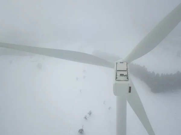 Aerial view of wind turbine in snow covered landscape