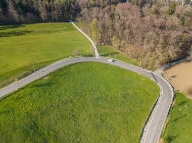 Kırsal kesimden geçen yolun havadan görünüşü. Asfalt yolunun yanındaki çim tarlaları. Kırsal kesime yolculuk kavramı.