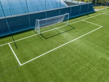Futbol kalesi ve penaltı sahasının havadan görünüşü. Beyaz çizgileri olan boş futbol sahası.