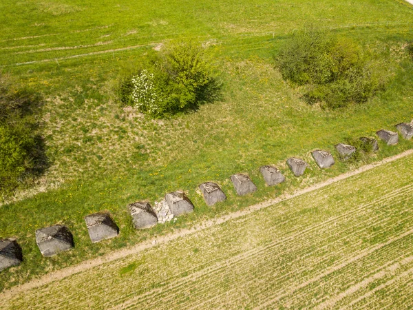 Aerial view of old tank barrier in Switzerland. Massive stones serving as obstacles against tanks in overhead view. Concept of world war 2 defense.