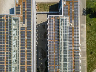 Elektrik üretimi için fotovoltaik paneli olan binaların çatılarının hava görüntüsü. Binalar için temiz enerji kavramı.