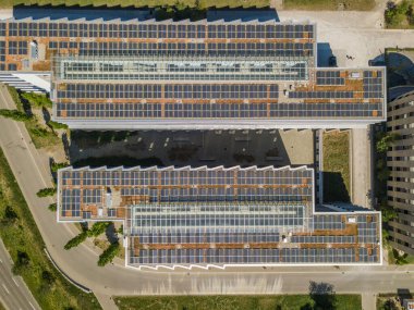 Elektrik üretimi için fotovoltaik paneli olan binaların çatılarının hava görüntüsü. Binalar için temiz enerji kavramı.