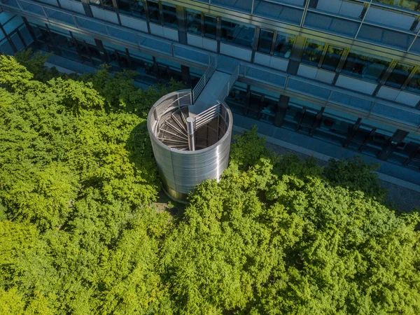 Aerial view of spiral emergency staircase outside on residential building leading down in park. Concept of emergency exit.