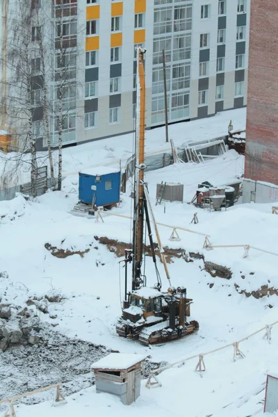 冬の工事現場には杭打ち装置付きトラクターが立っている。 — ストック写真