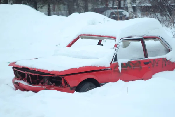 冬天，一辆被雪覆盖的破车停在城市街道上 — 图库照片