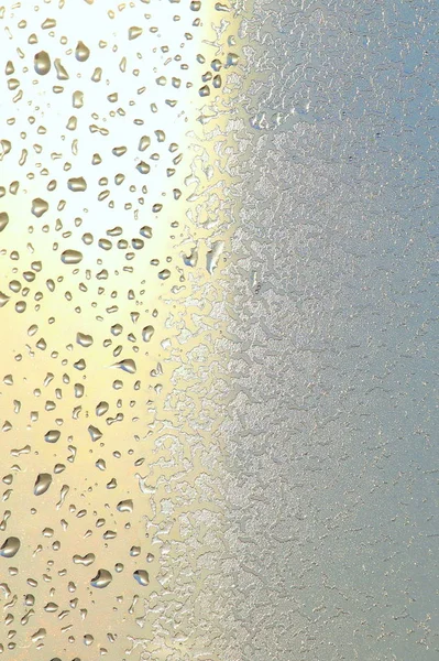 Niebieskie okno szkło pokryte chrypka wzór lodu z kroplami wody. Zimne zimowe tło natury — Zdjęcie stockowe