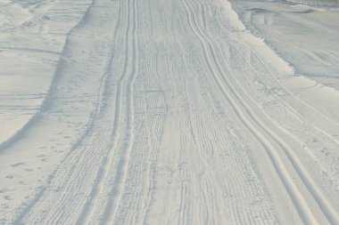 Karda sıyrılmış ayak izleri kar arabasında.