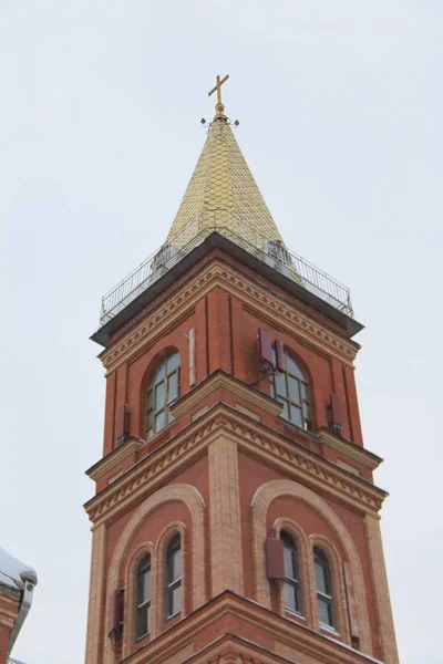 Fragment d'une église en brique rouge avec fenêtres et toit doré — Photo