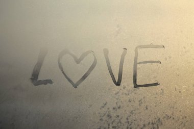 Aşk sözcüğü dondurulmuş bir pencere konseptine yazılmış Sevgililer Günü.