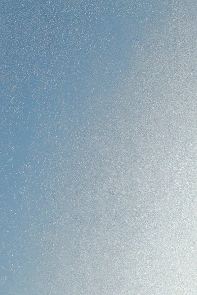 Blå fönster glas täckt hes is mönster konsistens. Kall natur vinter bakgrund — Stockfoto