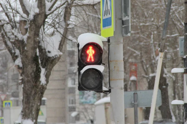 Verkeerslichten voor voetgangers met een rood licht in de vorm van een menselijke figuur op een pilaar in de stad — Stockfoto