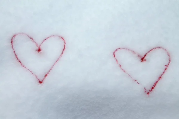 Two red hearts painted with red paint on snow symbol of love postcard for Valentines Day