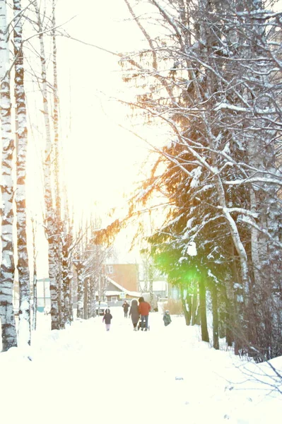Menschen gehen an einem sonnigen Wintertag die Straße entlang. — Stockfoto