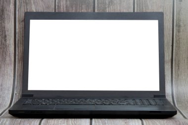 A laptop with a white screen stands on the background of wooden boards. Place for text, layout for design