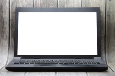 A laptop with a white screen stands on the background of wooden boards. Place for text, layout for design