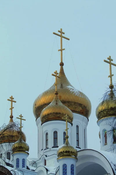 Złote kopuły i krzyże białego prawosławnego kościoła chrześcijańskiego na tle nieba — Zdjęcie stockowe