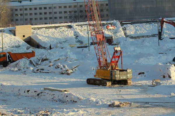 Large crawler crane works at a construction site on a frosty sunny day in winter in Russia — ストック写真