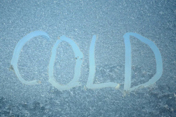 Inskriptionen på frusen fönsterruta, ordet kall — Stockfoto