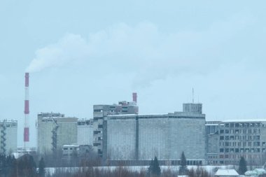 Bulutlu gri gökyüzüne karşı terk edilmiş sanayi bölgesi.