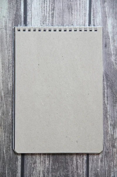 Сірий листовий папір з спірального ноутбука лежить на тлі дерев'яних дощок — стокове фото