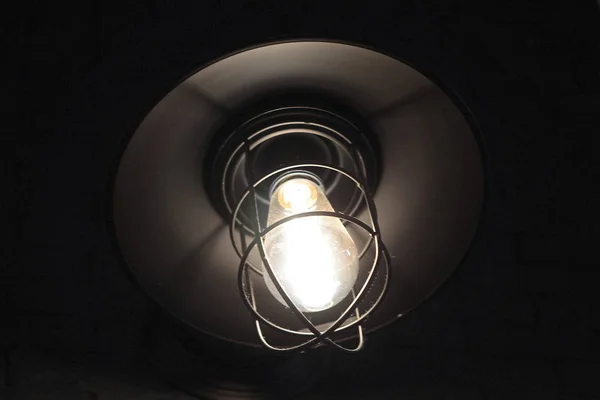 गडद पार्श्वभूमीवर आधुनिक औद्योगिक लिफ्ट शैली मध्ये चमकदार दिवा — स्टॉक फोटो, इमेज
