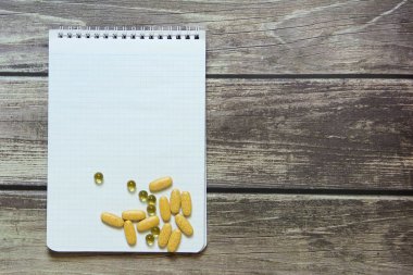 Dama kağıdında boş beyaz bir sayfa ve tahta tabloların üzerinde haplar olan bir not defteri.