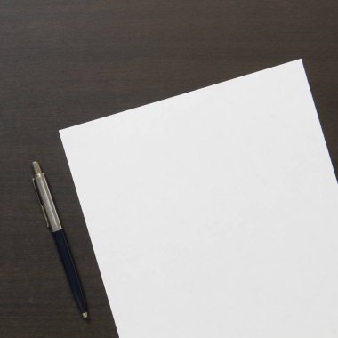 Koyu renkli ahşap arka planda beyaz kağıt şablonu. İş planı ve stratejisi kavramı. Metin ve tasarım için boş alanı olan stok fotoğrafı.