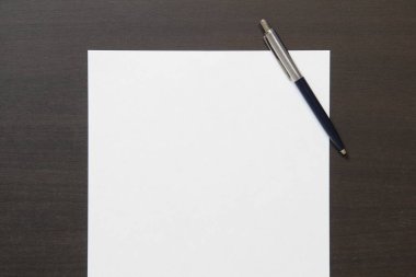 Koyu renkli ahşap arka planda beyaz kağıt şablonu. İş planı ve stratejisi kavramı. Metin ve tasarım için boş alanı olan stok fotoğrafı.
