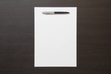 Koyu renkli ahşap arka planda beyaz kağıt şablonu. İş planı ve stratejisi kavramı. Metin ve tasarım için boş alanı olan stok fotoğrafı.