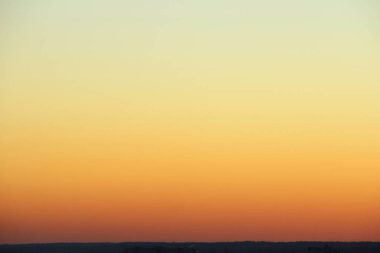 Gün batımında ya da gün doğumunda ufukta parlayan gökyüzü. Sarı, turuncu ve kırmızı parlak renkler. Metin ve tasarım için renkli arkaplan.