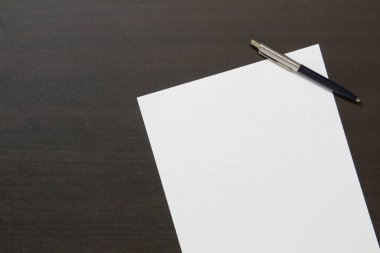 Koyu renkli ahşap arka planda beyaz kağıt şablonu. İş planı ve stratejisi kavramı. Metin ve tasarım için boş alanı olan stok fotoğrafı.