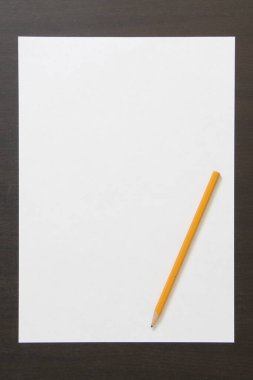 Koyu renkli ahşap arka planda beyaz kağıt ve kalem şablonu. İş planı ve strateji kavramı, içeriğin geliştirilmesi ve uygulanması. Metin için boş alanı olan stok fotoğrafı. 