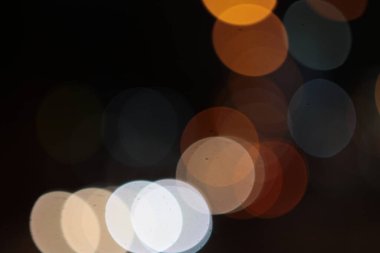 Aydınlık noktalar gecenin karanlığında çok renkli arka planda parlıyor, parlıyor. Çelenk.