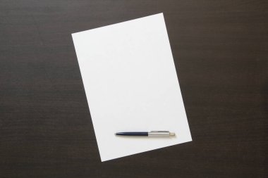 Koyu renkli ahşap arka planda beyaz kağıt şablonu. İş planı ve stratejisi kavramı. Metin ve tasarım için boş alanı olan stok fotoğrafı.