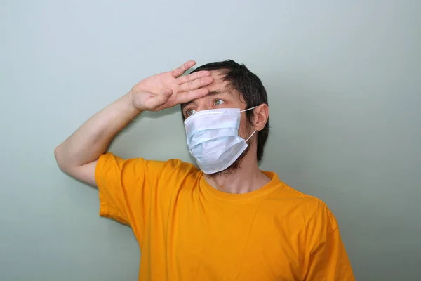 Μεσήλικας Άντρας Κίτρινη Μπλούζα Γκρι Φόντο Ιατρική Μάσκα Κρατάει Χέρι — Φωτογραφία Αρχείου