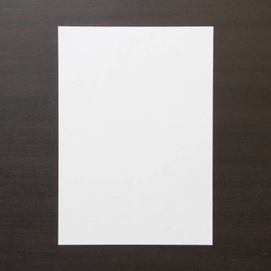 Koyu renkli ahşap zemin üzerine beyaz kağıt şablonu. Yeni fikir, iş planı ve strateji kavramı, içeriğin geliştirilmesi ve uygulanması. Metin için boş alanı olan stok fotoğrafı.