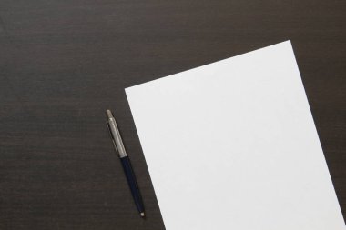 Koyu renkli ahşap arka planda beyaz kağıt şablonu. İş planı ve stratejisi kavramı. Metin ve tasarım için boş alanı olan stok fotoğrafı.