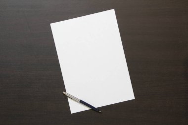 Koyu renkli ahşap arka planda beyaz kağıt şablonu. İş planı ve stratejisi kavramı. Metin ve tasarım için boş alanı olan stok fotoğrafı.