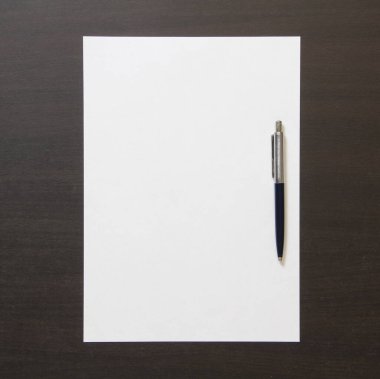 Koyu renkli ahşap arka planda beyaz kağıt şablonu. İş planı ve stratejisi kavramı. Metin ve tasarım için boş alanı olan stok fotoğrafı.