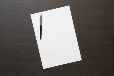 Koyu renkli ahşap arka planda beyaz kağıt şablonu. İş planı ve stratejisi kavramı. Metin ve tasarım için boş alanı olan stok fotoğrafı.